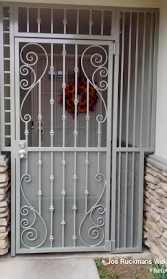 A custom gray steel entry enclosure with decorative scrollwork